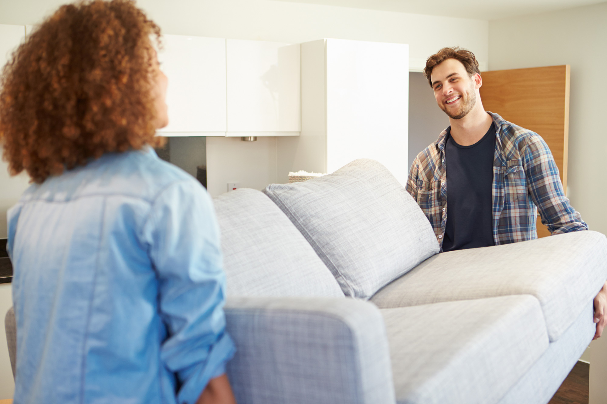 young couple moving couch 